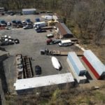 Close up aerial shot of contractor's yard with trucks and equipment