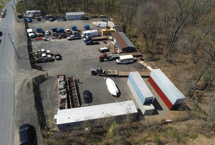 Close up aerial shot of contractor's yard with trucks and equipment